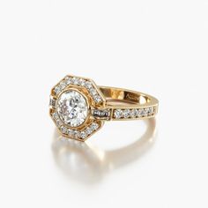 an engagement ring with diamonds on the side and a halo setting in yellow gold plated silver