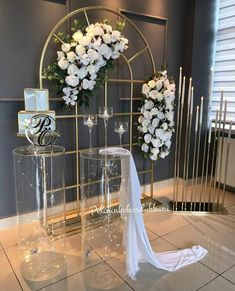 the wedding cake is on display in front of two tall vases with white flowers