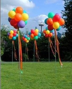 colorful balloons are floating in the air on sticks