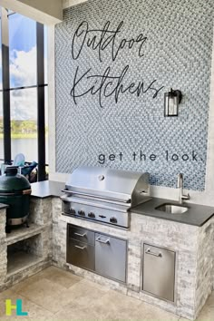 an outdoor kitchen with stainless steel appliances and grilling counter tops, next to a large window