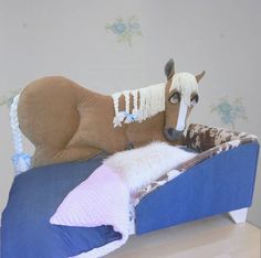 a stuffed horse laying on top of a blue bed