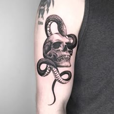 a man with a skull and snake tattoo on his arm