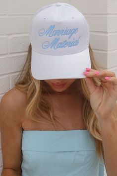 a woman wearing a white hat with the words marriage material printed on it's front