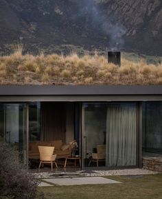 a house with a grass roof and sliding glass doors