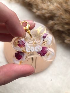 a person holding a small glass ornament with flowers on it