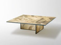 a wooden table with glass top sitting on a white surface