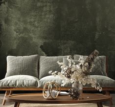 a living room with a couch, table and vase on top of the coffee table