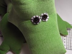 a green stuffed animal with black and white flowers