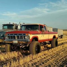 two trucks are parked in the middle of a field