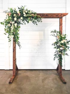 a wooden arch with flowers and greenery on it