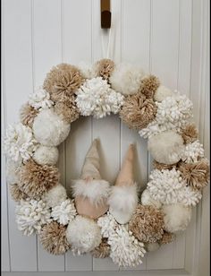 a wreath with pom - poms and gnomes on it