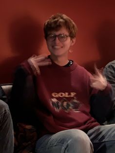 a man sitting on top of a couch wearing glasses