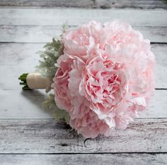 a bouquet of pink flowers sitting on top of a wooden table