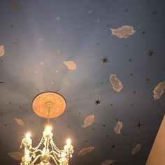 a chandelier hanging from the ceiling in a room with stars painted on it