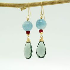 "Moss Aquamarine and Teal Quartz Earrings A stunning Teal-coloured Quartz Briolettes are dangling below large (10mm) Blue Moss Aquamarine beads accented with raspberry Ruby beads. The Briolette and The gems are wrapped with high quality 14k gold filled wire and swing from a gold filled hook. These are natural, not colourd excellent AAA quality gems, beautifuly faceted and sparkling. An elegant and feminine, chic statement earrings, perfect for special occasion, wedding, holidays or as a Gift for Blue Aquamarine Gemstone Earrings, Aquamarine Drop Earrings With Ear Wire, Blue Gemstone Accented Drop Earrings, Blue Drop Earrings With Gemstone Accents, Blue Drop Earrings With Ethical Gemstones, Blue Drop Earrings With Natural Stones, Elegant Aquamarine Earrings With Ear Wire, Handmade Elegant Aquamarine Earrings, Teal Jewelry