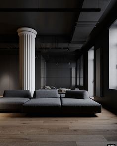 a couch sitting in the middle of a living room next to a tall white column