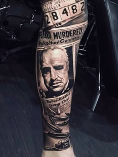 a man's leg with an old movie poster on it and his name tattooed