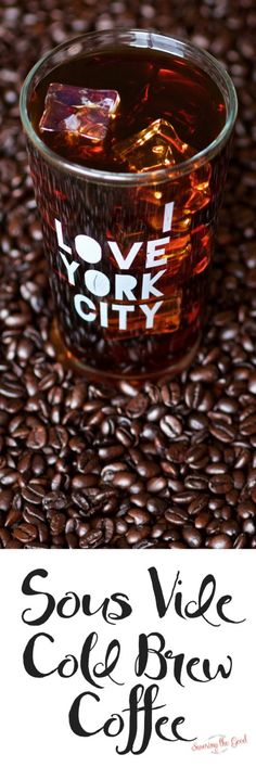 a glass cup filled with liquid sitting on top of coffee beans next to a sign that says love story