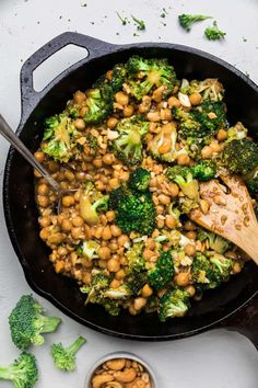 broccoli and chickpeas in a skillet with a wooden spoon