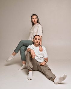 two people sitting on the ground posing for a photo