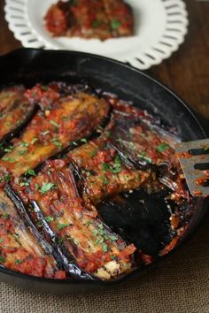 an eggplant dish in a skillet on a table