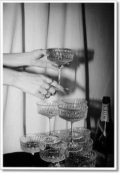 black and white photograph of woman's hands with manicures holding wine glasses