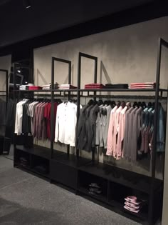 a clothing rack with shirts and pants on display in a store or office space,