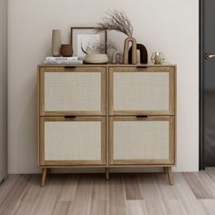 an empty room with a wooden cabinet next to a door and pictures on the wall