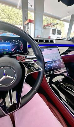 the inside of a car with dashboard, steering wheel and display screen showing various vehicles