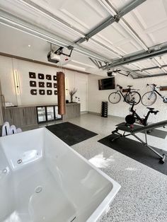 there is a large white bathtub in the middle of a room with bikes on it