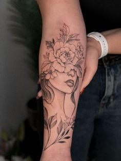 a woman's arm with a flower tattoo on it