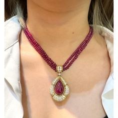 This is part of Chairish’s Fine Jewelry assortment.  This captivating pendant necklace, showcases a mesmerizing 22.41 carat, deep pink ruby cabochon cut, securely set in a classic bezel mounting crafted from 18k yellow gold. The weight of the piece is 27.57 grams. GRS certified, the ruby is surrounded by 144 sparkling diamonds and further complemented by 7 elegant emerald cut diamonds, totalling approximately 13-15 carats. A beaded ruby chain completes this luxurious and unique statement piece. Diamond Cabochon Pendant Necklace, Luxury Yellow Gold Ruby Necklace, Luxury Ruby Necklace In Yellow Gold, Luxury Red Cabochon Necklaces, Luxury Red Cabochon Necklace, Luxury Pear-shaped Ruby Jewelry, Elegant Ruby Briolette Necklace, Elegant Cabochon Teardrop Pendant Necklace, Elegant Teardrop Pendant Cabochon Necklace