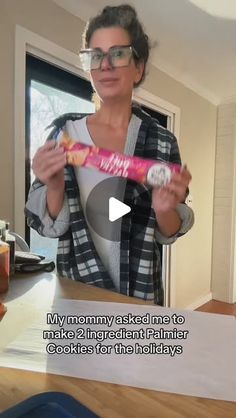 a woman holding up a pink candy bar in her hands