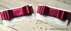 two wedding place cards with bows on them