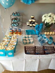 a table topped with lots of desserts and cupcakes on top of it