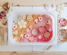 a plastic container filled with lots of different types of candies and other treats on top of a table