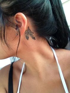 a woman with a tattoo on her neck and behind her ear is looking out the window