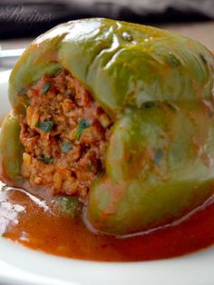 stuffed peppers with meat and sauce on a white plate