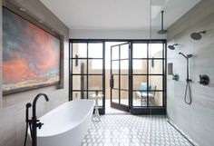 a bathroom with a large painting on the wall and a white bathtub in front of it