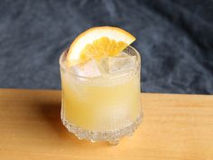 a glass filled with lemonade sitting on top of a wooden table