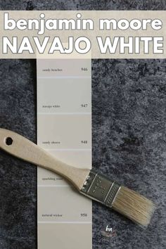 a paint brush sitting on top of a white sheet of paper with the words, benjamin moore navajo white