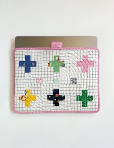 a laptop computer case is decorated with colorful crosses