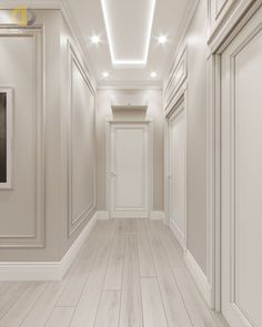 an empty hallway with white walls and wood flooring is lit by recessed lighting