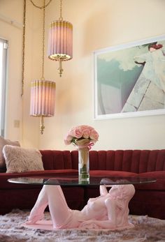 a living room with a couch, coffee table and chandelier