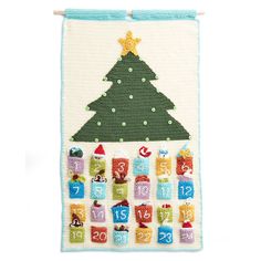 a cross stitch christmas tree hanging on a wall