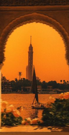 a sailboat is in the water under an arch