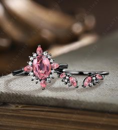 two hair clips with pink stones on them sitting on a table next to a book