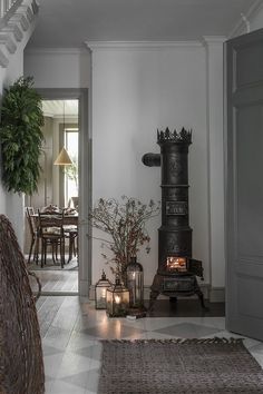 an old fashioned stove is in the middle of a dining room with candles and potted plants