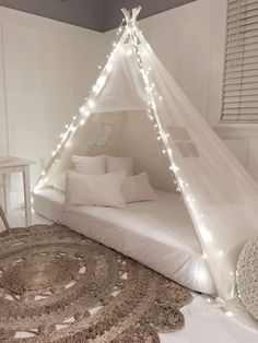 a white teepee bed with lights on it