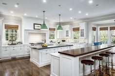 a large kitchen with wooden floors and white cabinets